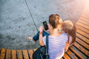 mamma che guarda lo smartphone con la figlia